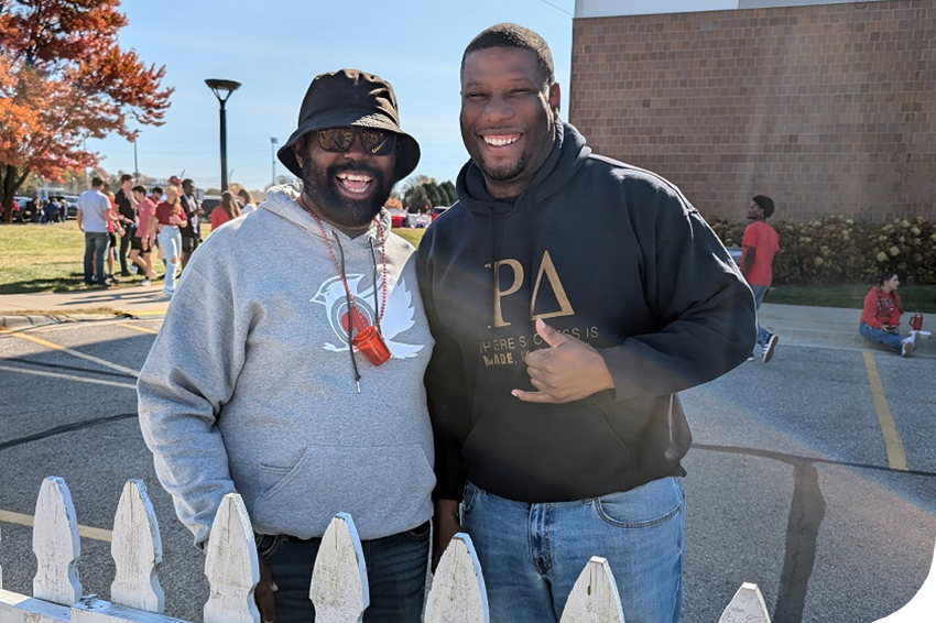 2 alumni smiling at homecoming